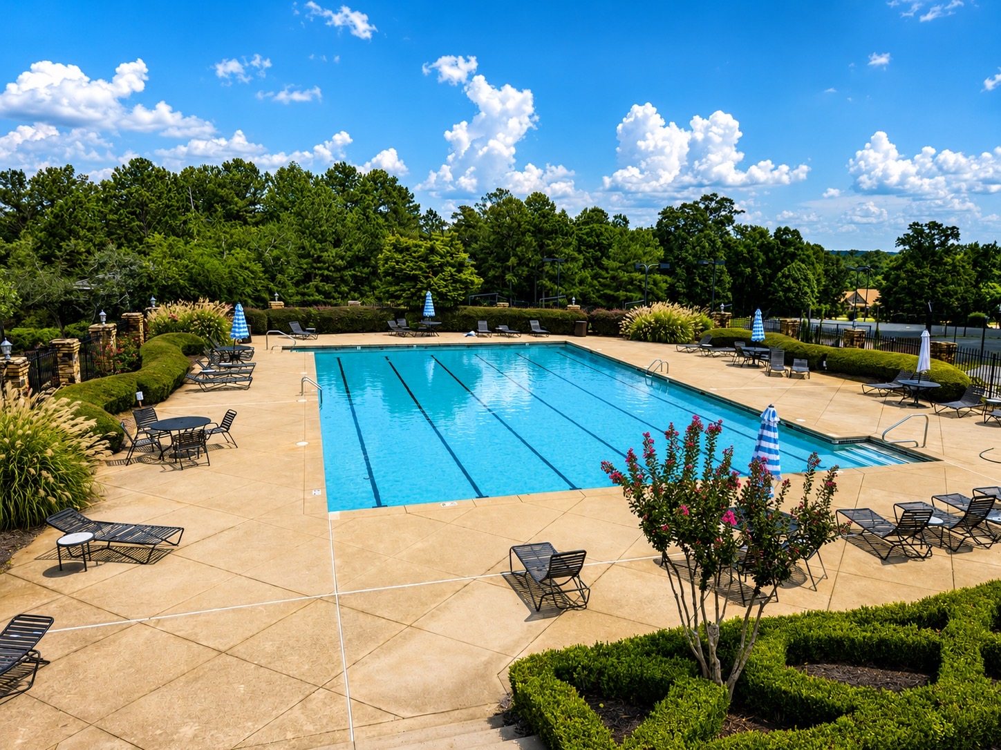 Landscaped outdoor community swimming pool with lounge seating